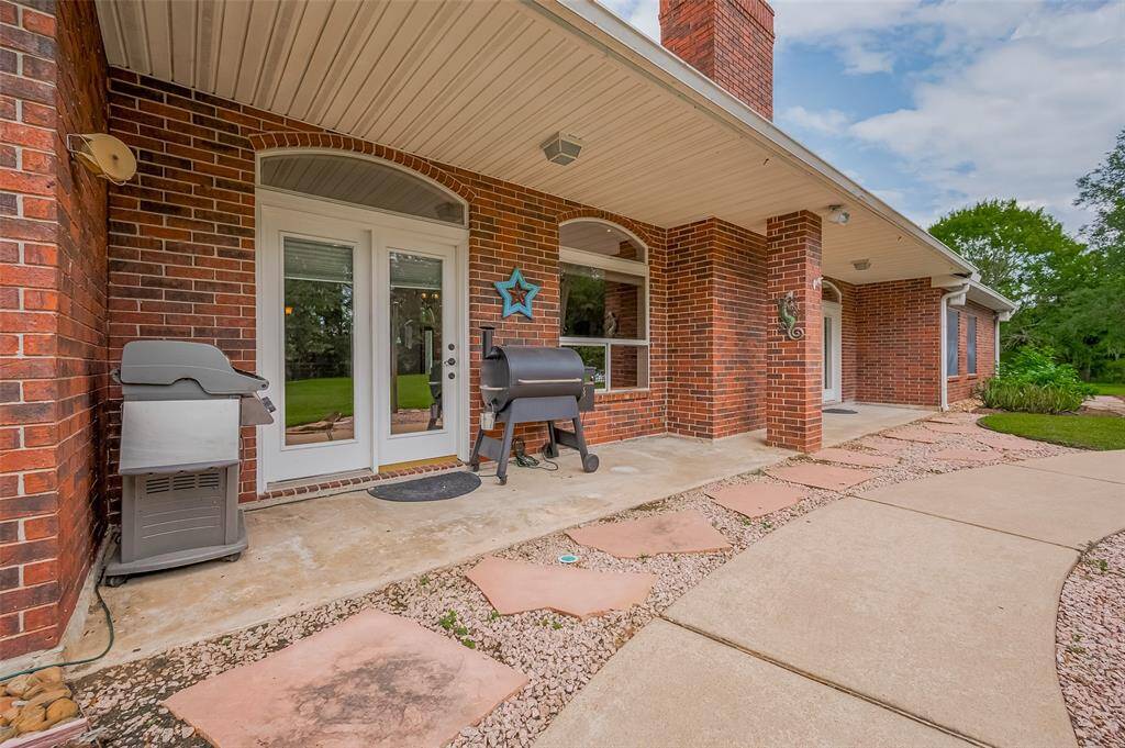 Step out onto the spacious covered back patio — the perfect spot for grilling, relaxing, and enjoying the great outdoors. Overlooking an expansive, private backyard, this outdoor space is ideal for summer cookouts or quiet evenings taking in the view.