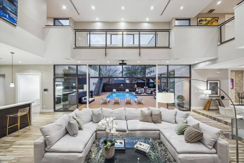 This photo showcases a spacious, modern living area with high ceilings and abundant natural light. The open layout provides a seamless flow between living and dining spaces, ideal for entertaining.