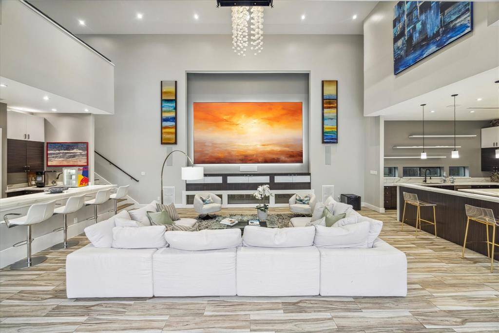 This photo showcases a spacious, modern living area with high ceilings and abundant natural light. The open layout provides a seamless flow between living and dining spaces, ideal for entertaining.