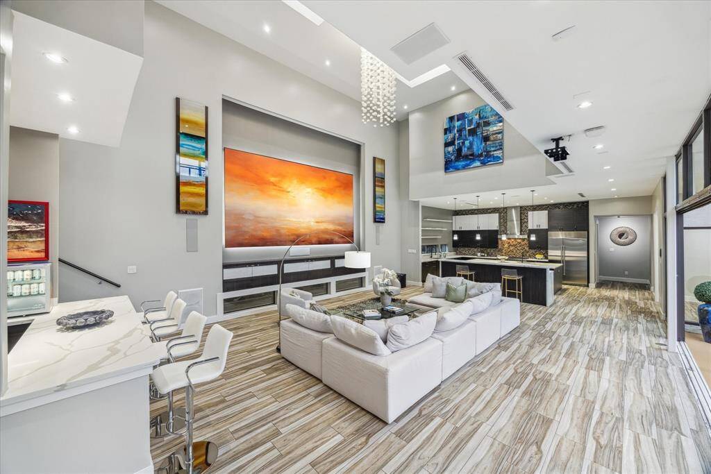 This photo showcases a spacious, modern living area with high ceilings and abundant natural light. The open layout provides a seamless flow between living and dining spaces, ideal for entertaining.