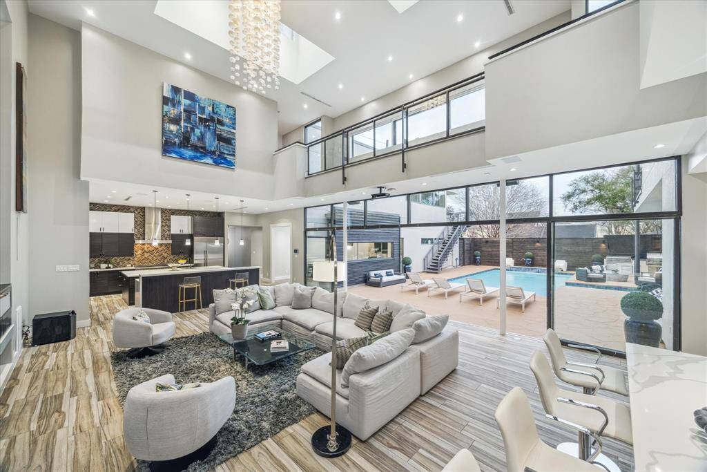 This photo showcases a spacious, modern living area with high ceilings and abundant natural light. The open layout provides a seamless flow between living and dining spaces, ideal for entertaining.