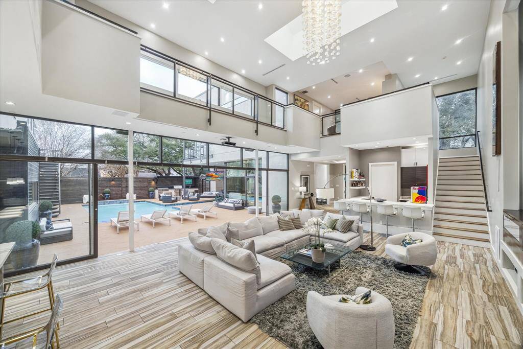This photo showcases a spacious, modern living area with high ceilings and abundant natural light. The open layout provides a seamless flow between living and dining spaces, ideal for entertaining.