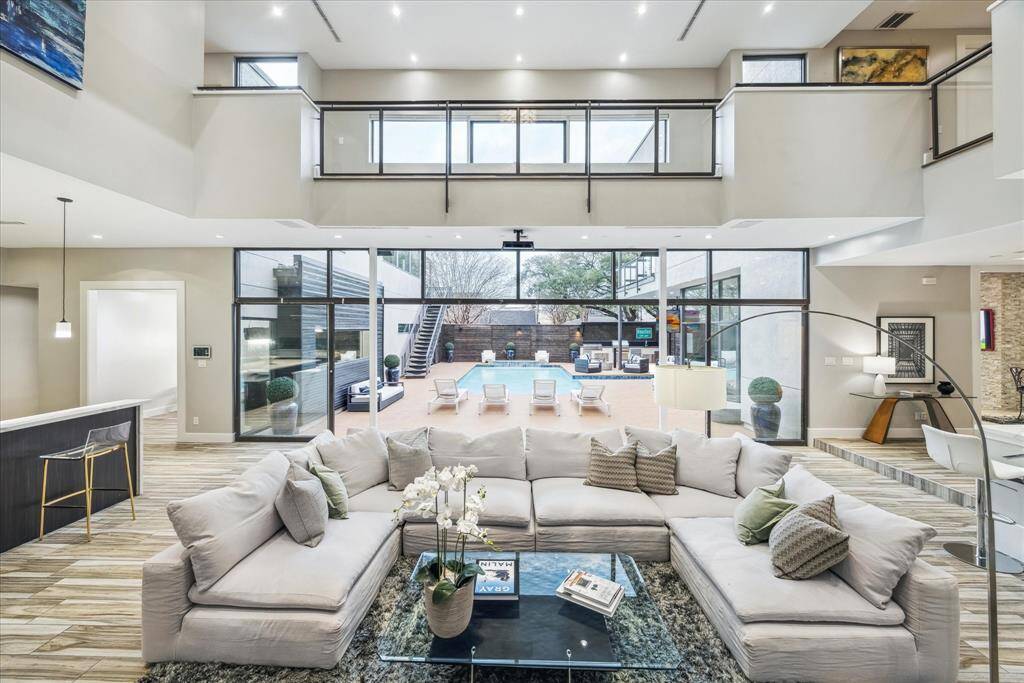 This photo showcases a spacious, modern living area with high ceilings and abundant natural light. The open layout provides a seamless flow between living and dining spaces, ideal for entertaining.