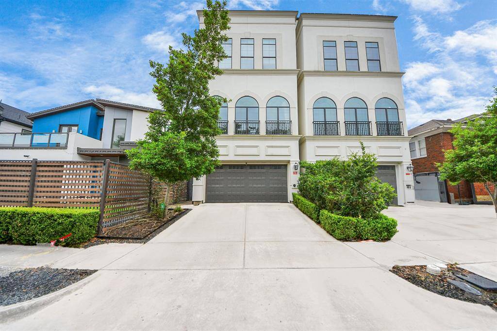 Street view of the house on the left, side entrance access, 2 car garage attached with extra parking on the drive way and street.