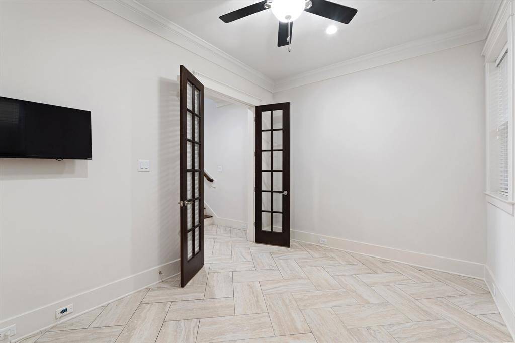 The first floor bedroom features tile floors, large windows, and a ceiling fan.