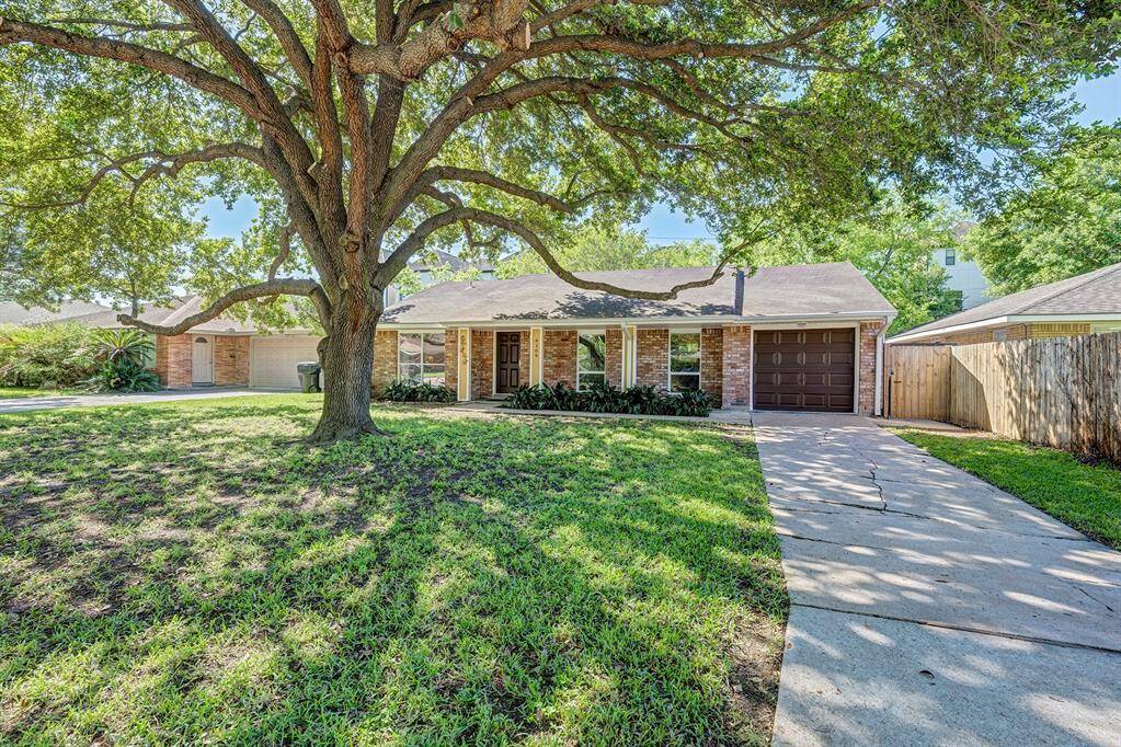 Charming home with a large tree in the front yard. Features include a porch, one-car garage, and a spacious driveway. Ideal for those seeking a peaceful, suburban setting.
