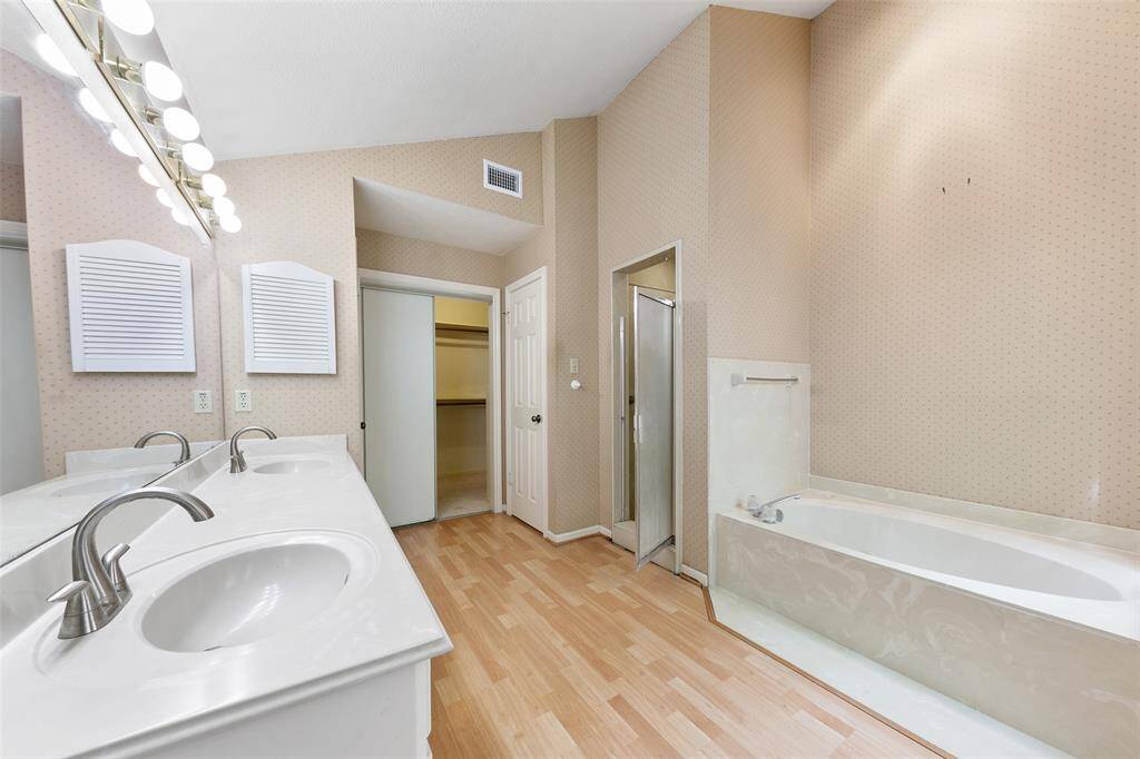 Primary bathroom with a separate tub and shower, along with dual vanities for added convenience and space.
