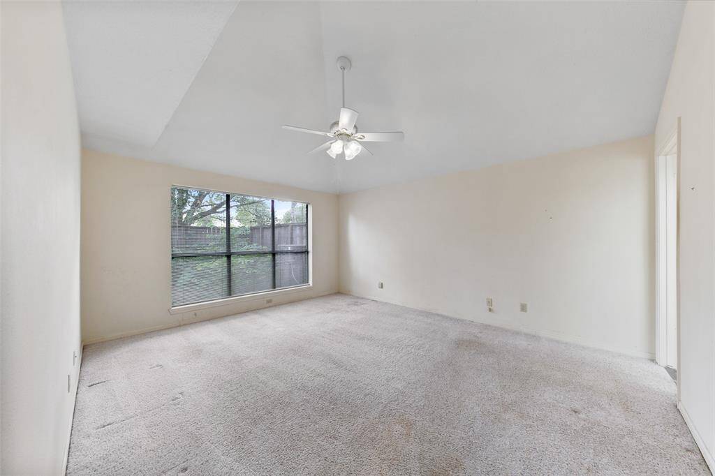 Primary bedroom with high ceilings, creating an open and airy atmosphere.