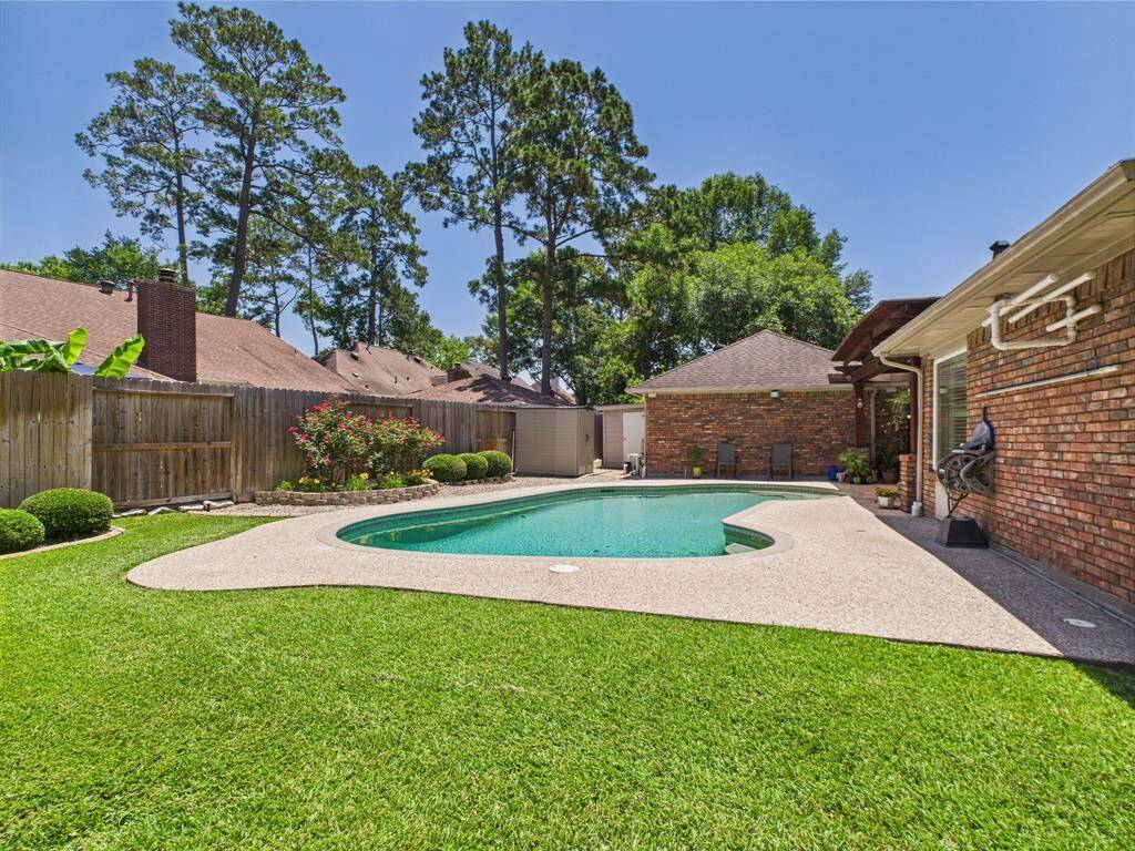 manicured flower beds surround the inground pool