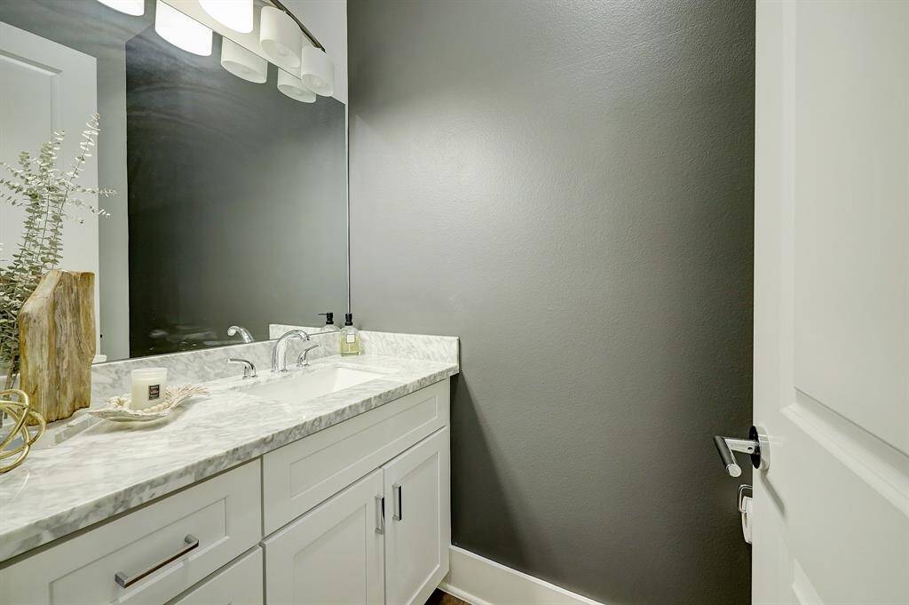 Powder bathroom features a beautiful countertop and accent wall.