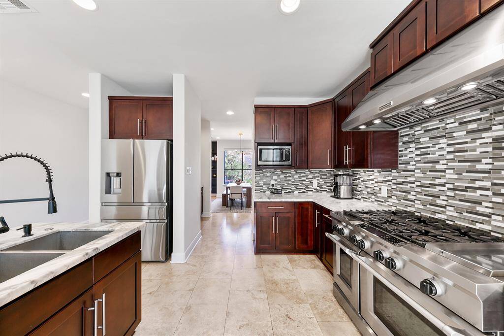 From the back, the view of the galley island kitchen towards the formal dining room is truly captivating. With its sleek design and high-end finishes, this showstopper kitchen is a chefs dream.
