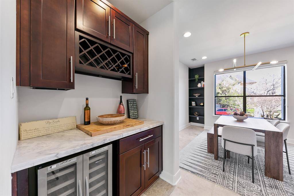 A marble-topped butler's pantry with solid wood cabinetry and a dual-climate wine chiller discreetly connects the kitchen and formal dining area, making it easy to host large holiday gatherings with style and ease.  Note: a large walk-in pantry is located opposite the butler's pantry (not shown).