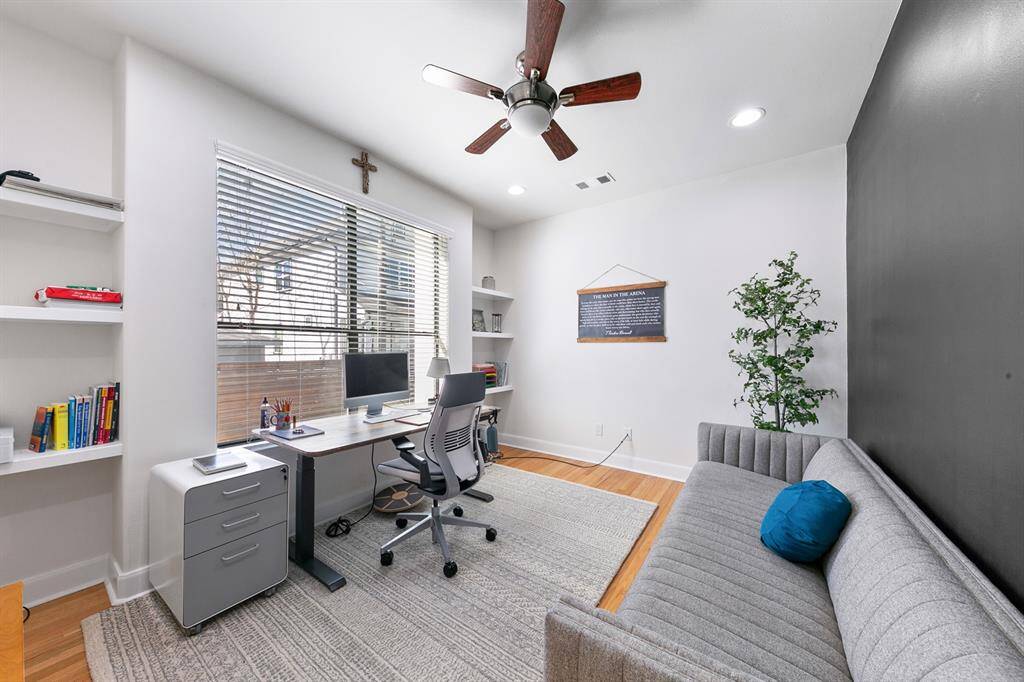 The home office, featuring engineered hardwood flooring, a large picture window, built-in floating bookshelves, and recessed lighting, is located down a private hall on the first floor off the living area offers beautiful views of the scenic backyard and pool. This versatile space could easily be converted into a second guest bedroom downstairs (a 5th bedroom) or a playroom.