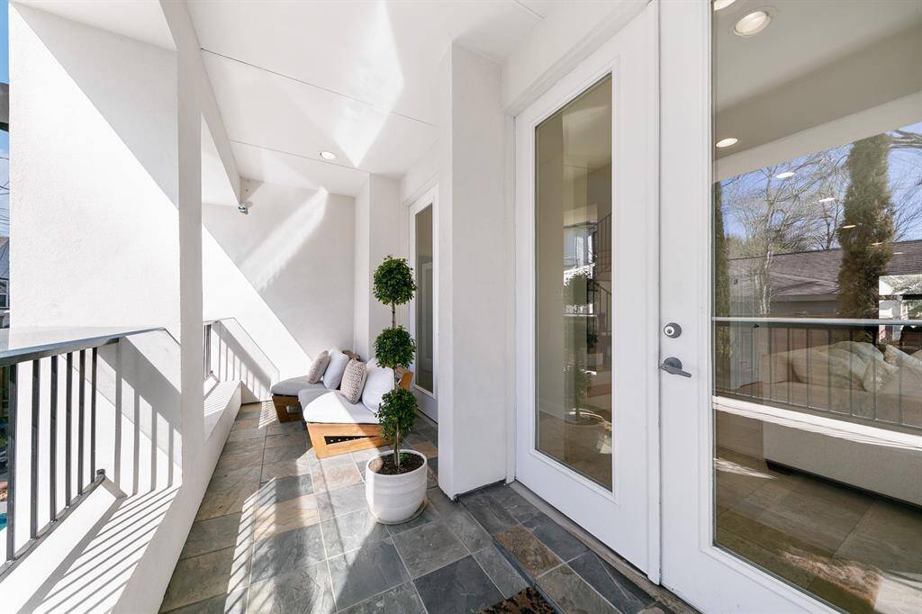 Double French doors with full glass panes open onto a covered porch as architecturally compelling as the interiors and front elevation.  Providing a perfect transition between indoor and outdoor living, this deep porch can easily flex from a quiet personal retreat to extra entertaining space with all the doors open wide.