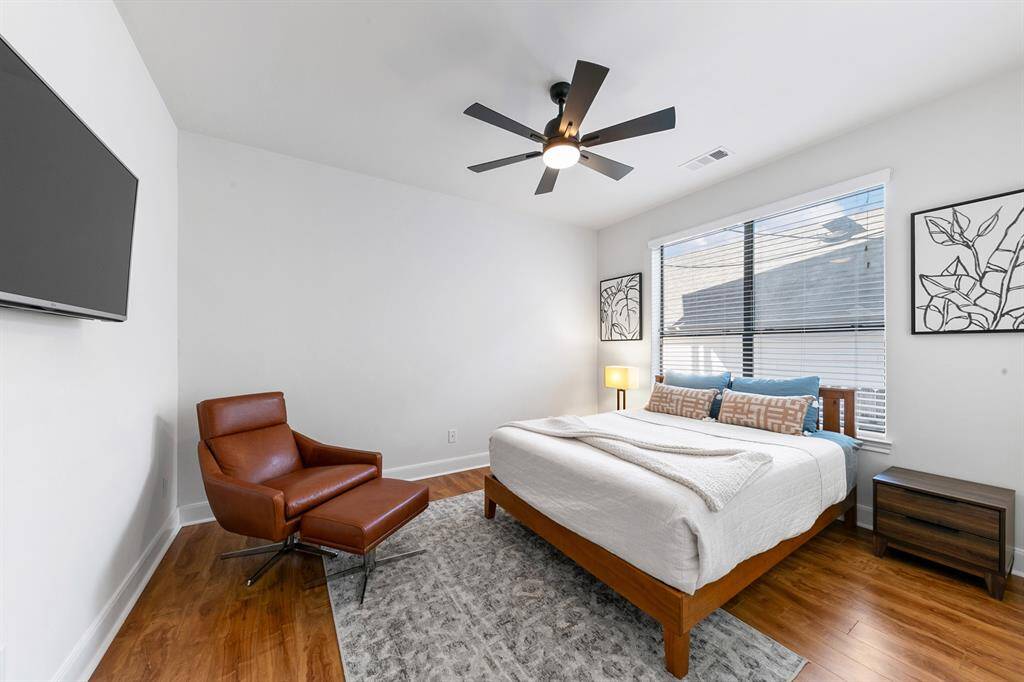 Back inside and located down a long hallway off the kitchen area, the secondary bedroom is adjacent to the full bath downstairs and features engineered hardwood flooring and a spacious closet.