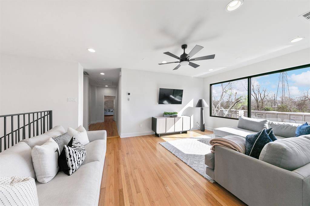 The openness of the floor plan extends to the second floor, where a cozy, sun-drenched den overlooks the spacious open areas of the easements adjacent to the property.  This more intimate living room features red oak hardwood flooring and provides a gracious transition between the common areas below and the bedrooms upstairs.  An adjacent game room (behind, not shown here) invites family and guests to relax and enjoy themselves in style, creating the perfect space for varied entertainment and fun.
