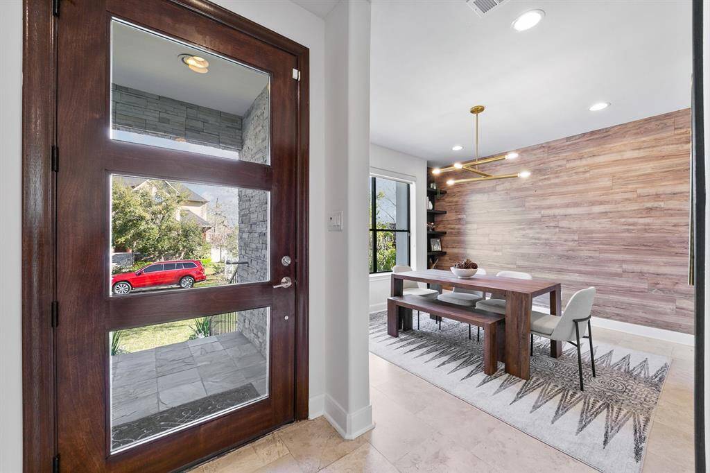 A sleek formal dining area overlooking the lush front yard greets friends and family upon entering the home.