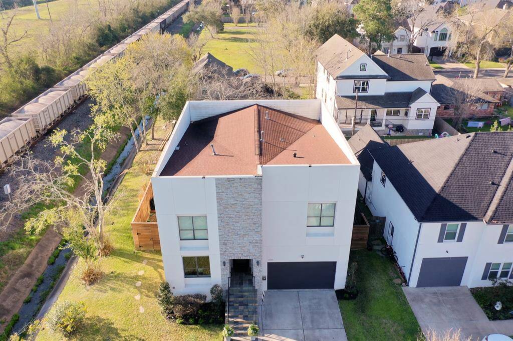 The vast openness of the oversized lot and surrounding easements, together with the charming nostalgia provided by the train cars passing by slowly and quietly, make the location of this contemporary gem in Bellaire incomparable.  Note the a hidden traditional peaked roof behind the modern facade (minimal concerns about water pooling, as is common with many flat contemporary roofs).