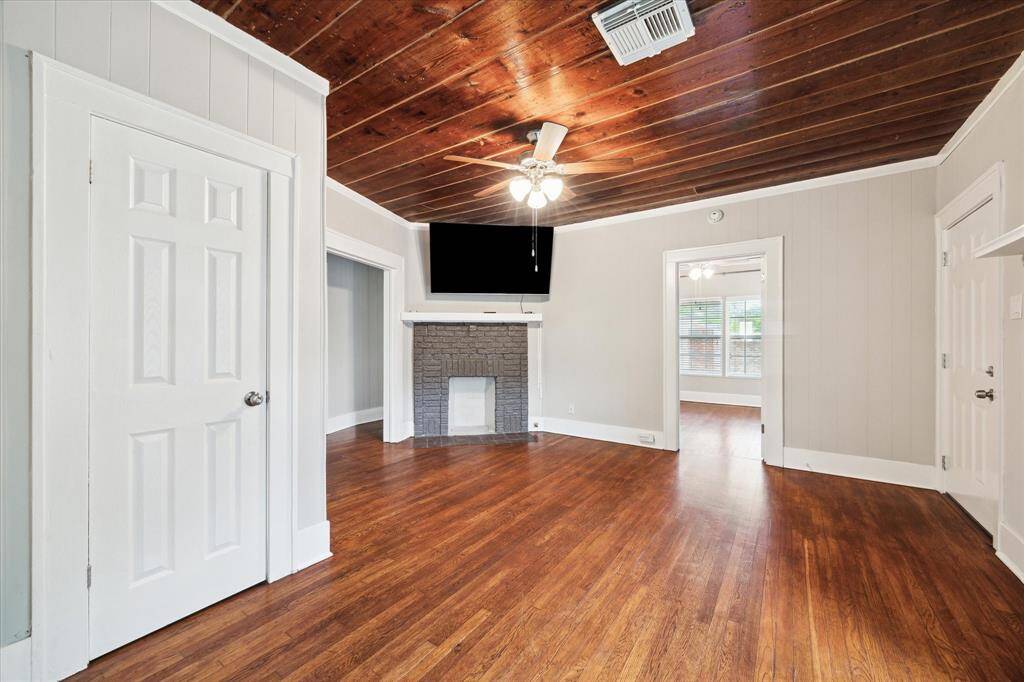 Another view of the living area showing the additional storage closet, door to patio (right), and corner mock fireplace