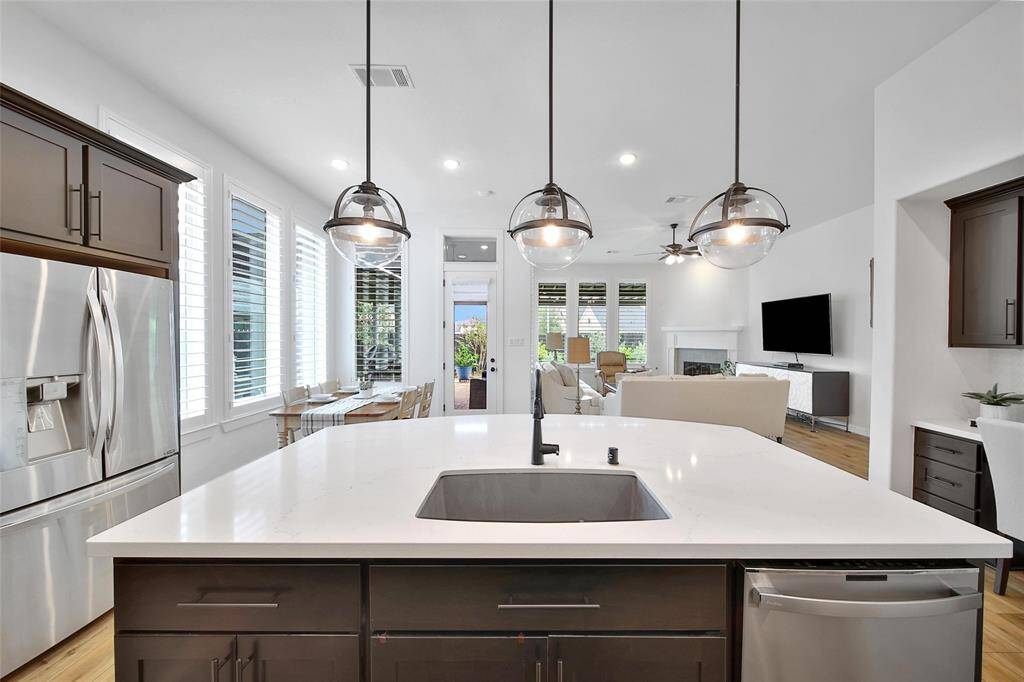 A trio of updated pendant light are suspended over the kitchen island. From snacks, to casual meals or just a spot to hang out...this island is sure to have everyone gathering around it!