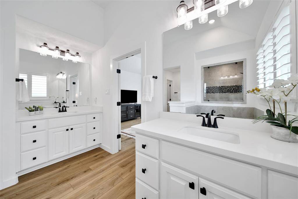A spa-like bathroom connected to the bedroom offers a serene retreat with luxurious features like a soaking tub, seperate shower, and soft lighting, creating a seamless blend of relaxation and comfort.