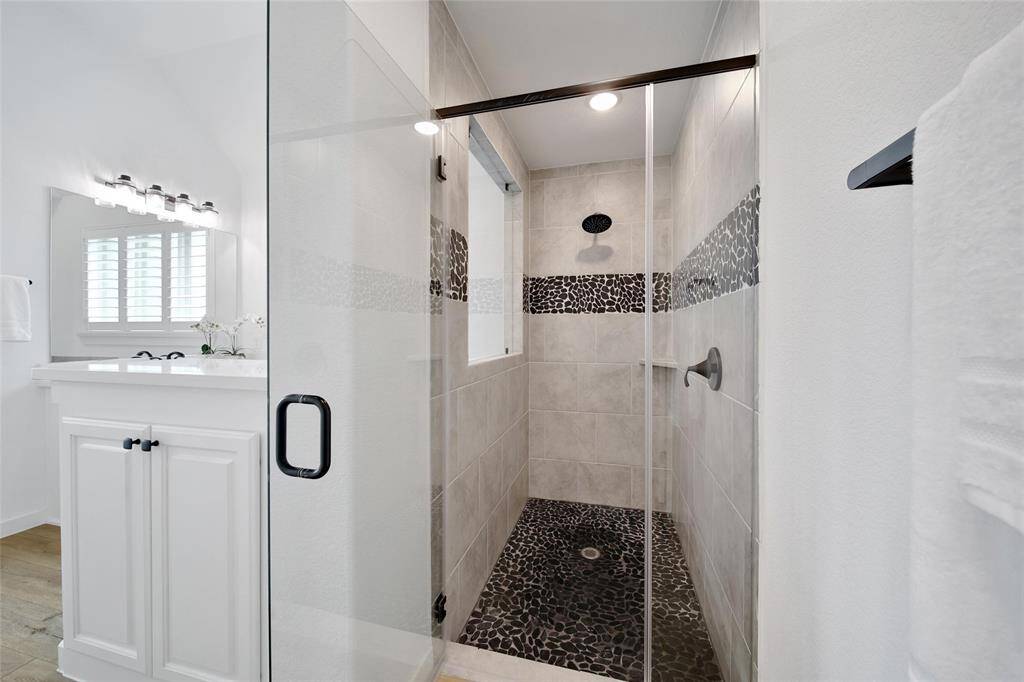Soothe away your worries in this stylish shower with river rock floor.