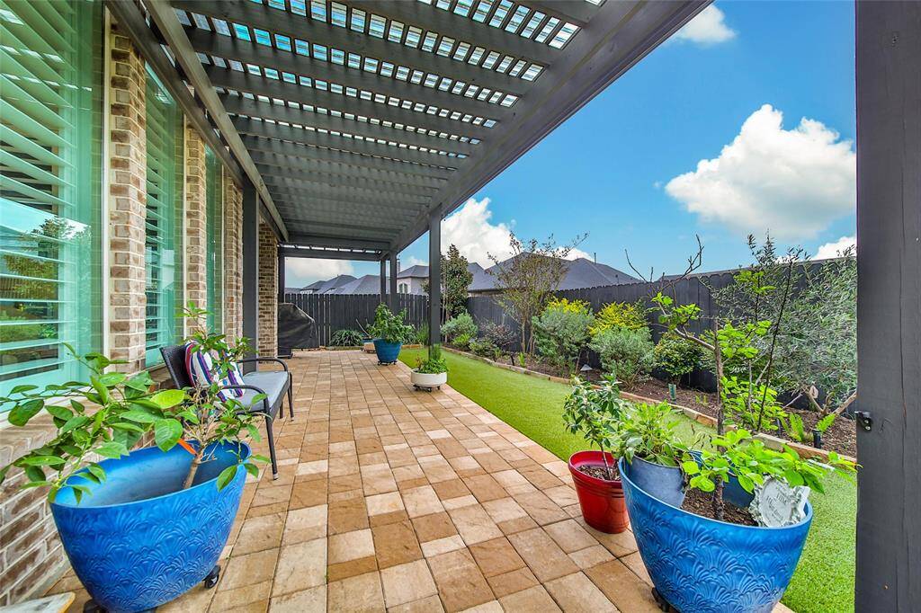 The covered patio has been extended to wrap around the house. Full gutters surround the perimeter of the home.
