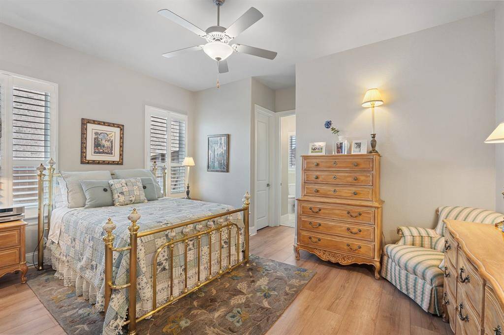 This bedroom features a window with privacy blinds, a ceiling fan for comfort, and a private en-suite bathroom for added convenience and privacy.