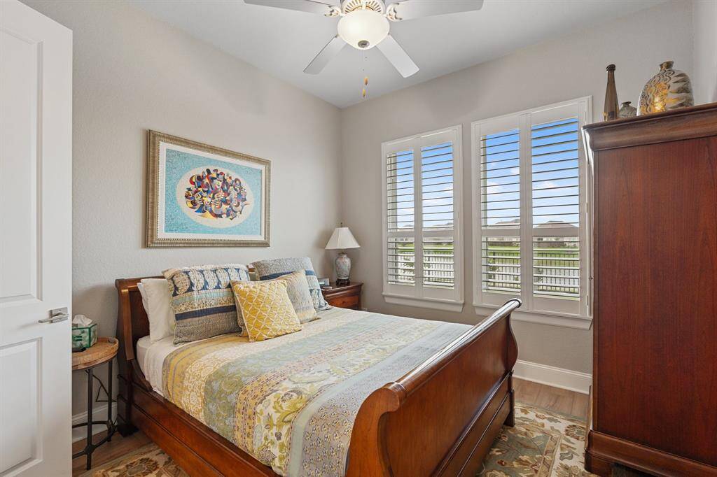 This charming bedroom boasts a window with privacy blinds, a ceiling fan for added comfort, custom paint that adds character, and a convenient ensuite bathroom for ultimate privacy.