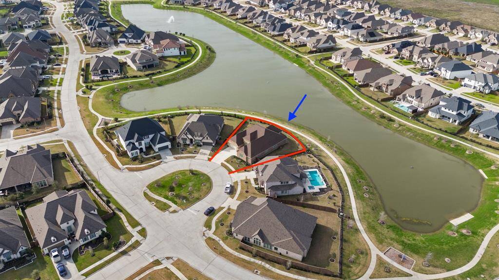 Enjoy breathtaking views with this stunning aerial shot of the home, perfectly situated on a picturesque lake lot, offering serene water views and a tranquil setting.