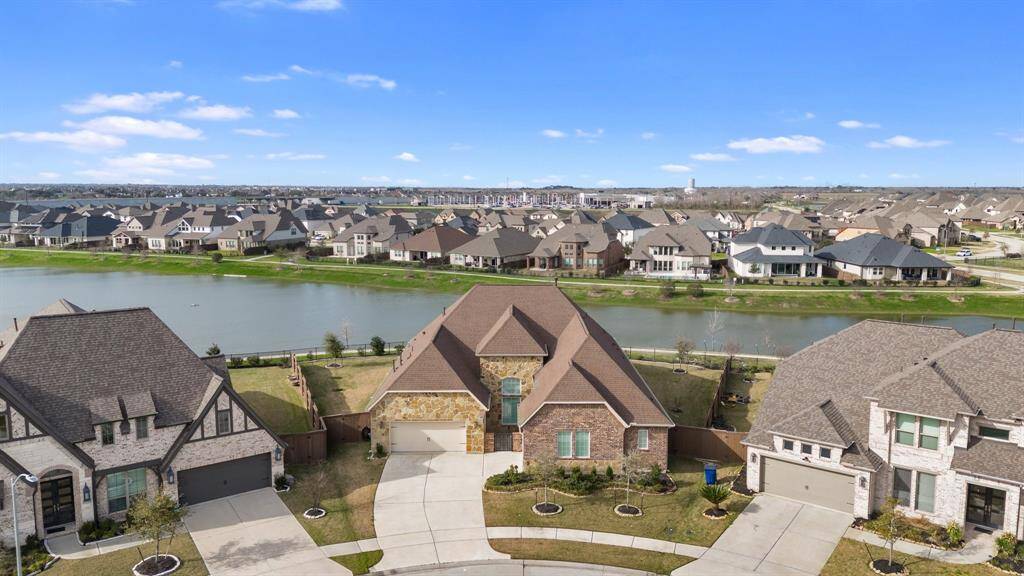 Take in the stunning aerial view of the front of this home, offering a glimpse of the beautiful neighborhood and its inviting surroundings.