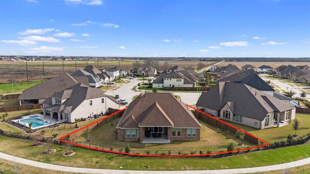 Enjoy the aerial view of the back of the home, showcasing the spacious backyard and the tranquil neighborhood that surrounds it.