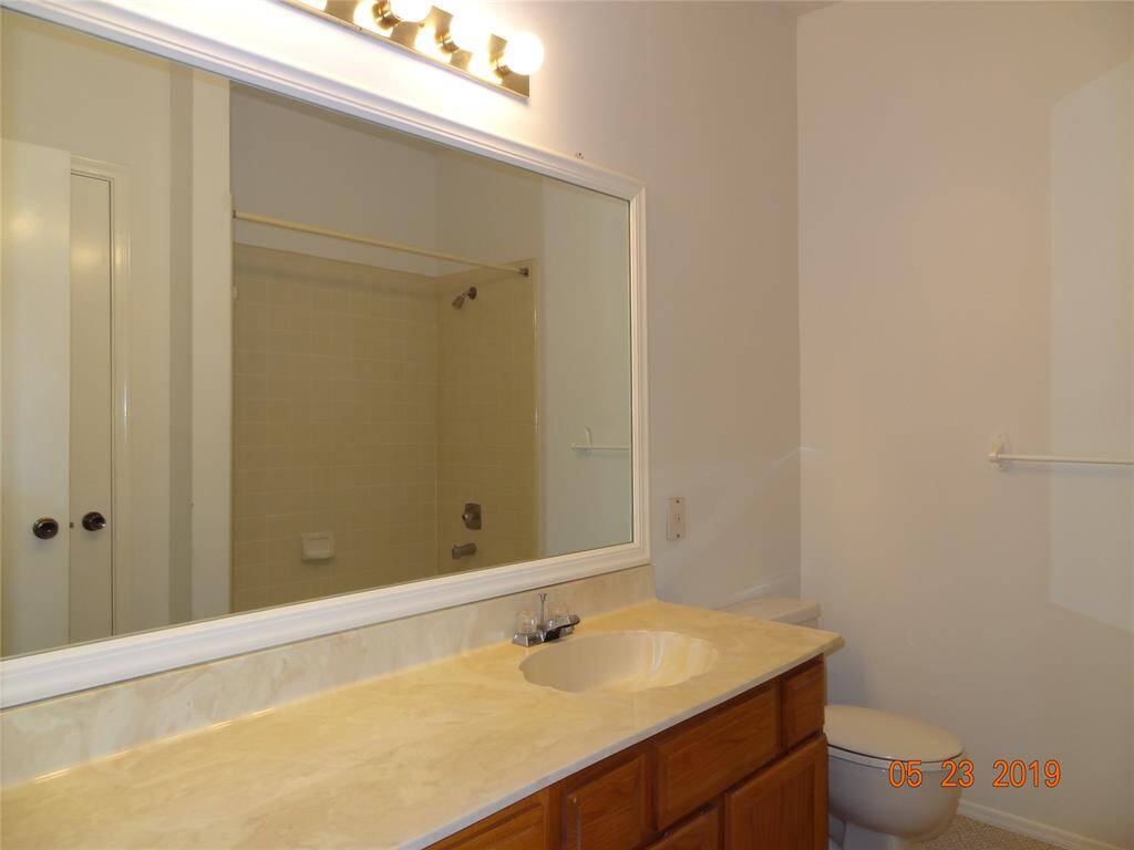 Large vanity area with sitting space. Framed mirror completes the look.