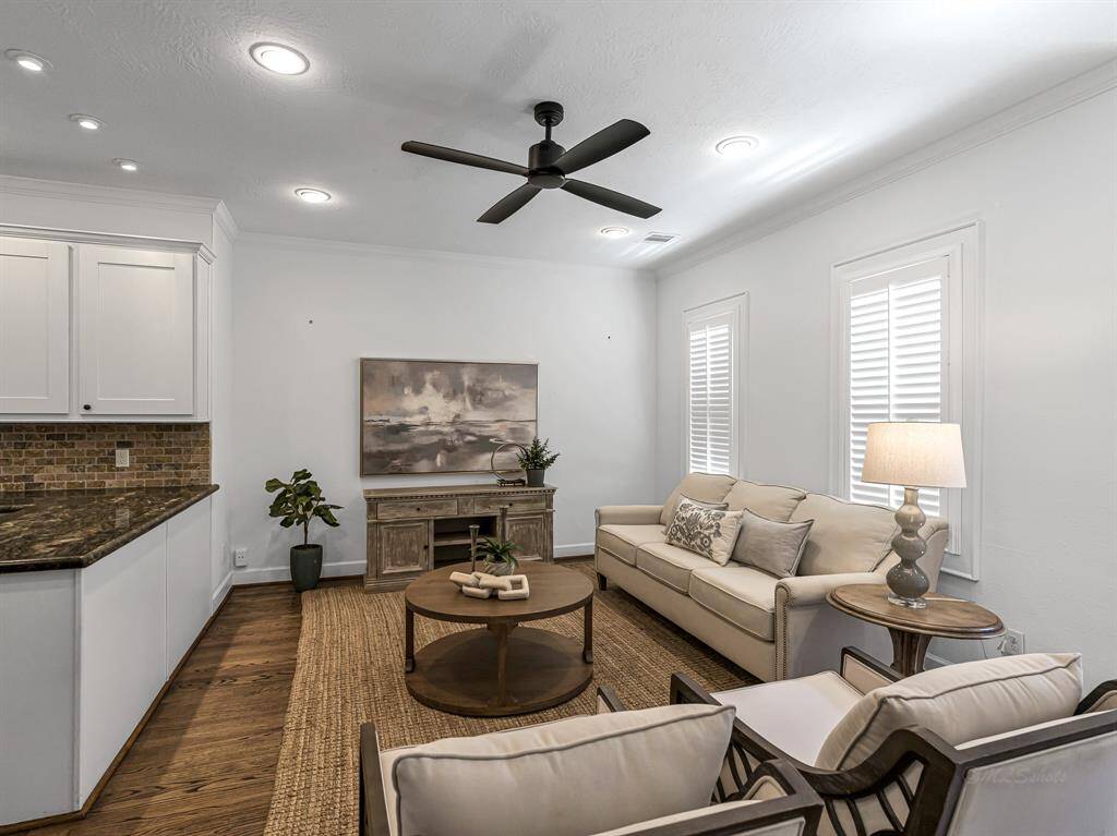 Hardwood floors extend into the family room, which also features recessed lighting, a ceiling fan, and plantation shutters. The room is wired for cable and offers direct access to the backyard.