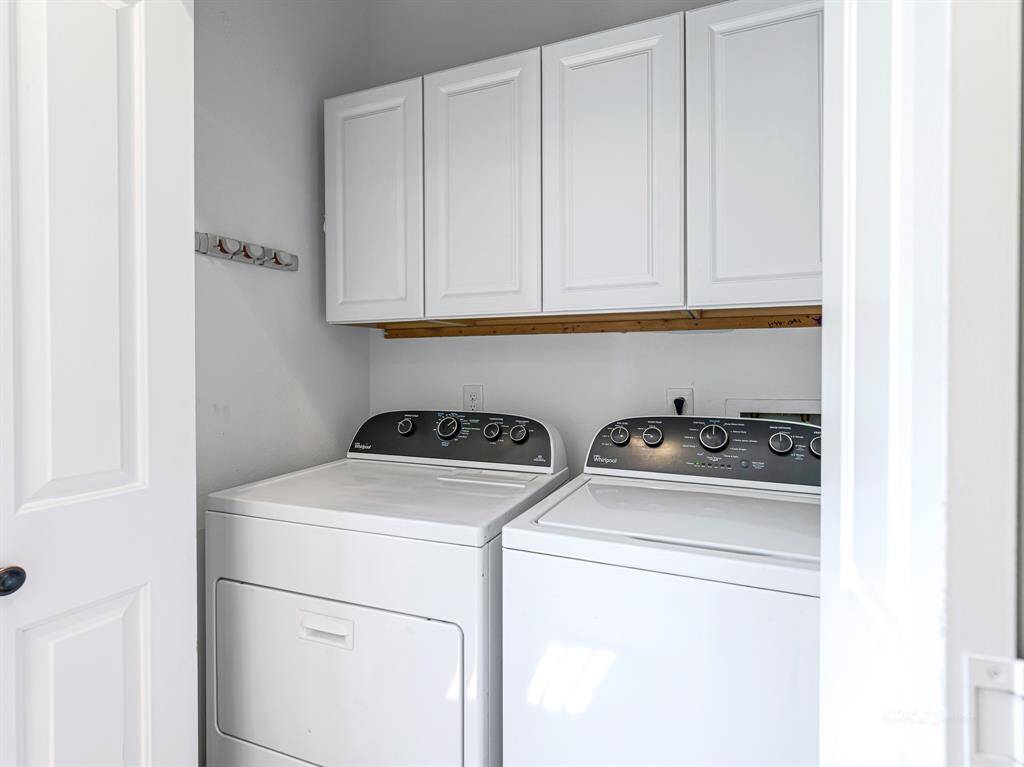 The washer and dryer are conveniently tucked behind pocket doors, with four built-in cupboards for additional storage.