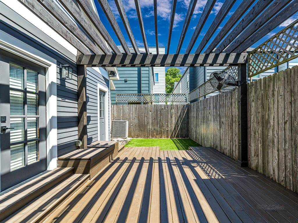 A charming pergola gracefully covers the dining area and deck, creating an inviting outdoor space perfect for al fresco dining and relaxation. French doors from the deck lead directly into the primary suite, offering seamless indoor-outdoor living