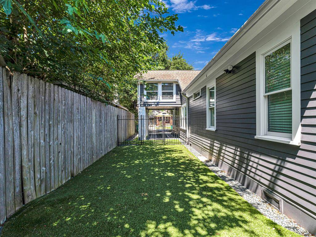 Additional artificial turf lines the backyard, enhancing the low-maintenance appeal of the space while maintaining a lush, green aesthetic. A privacy gate discreetly separates this area from the street, offering both security and a peaceful retreat.