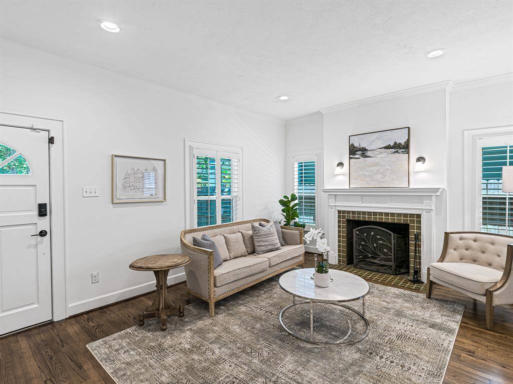 A fireplace with its original mantel and vintage sconces serves as a charming focal point, adding warmth and character to the room.