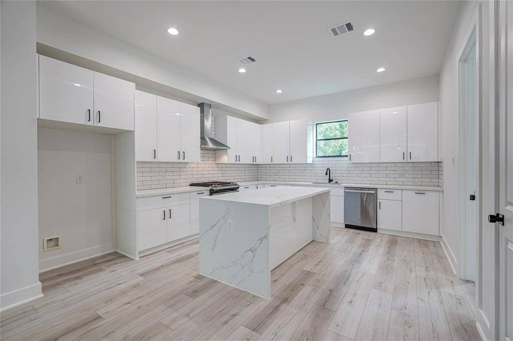 The kitchen includes lots of cabinets for storage and countertops for meal prep