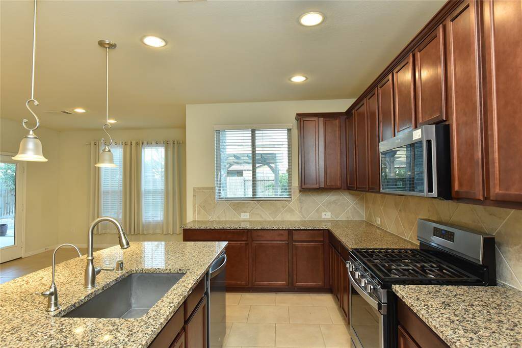 Spacious kitchen (14'11" x 19') with elegant countertops and ample cabinetry, perfect for cooking and entertaining.