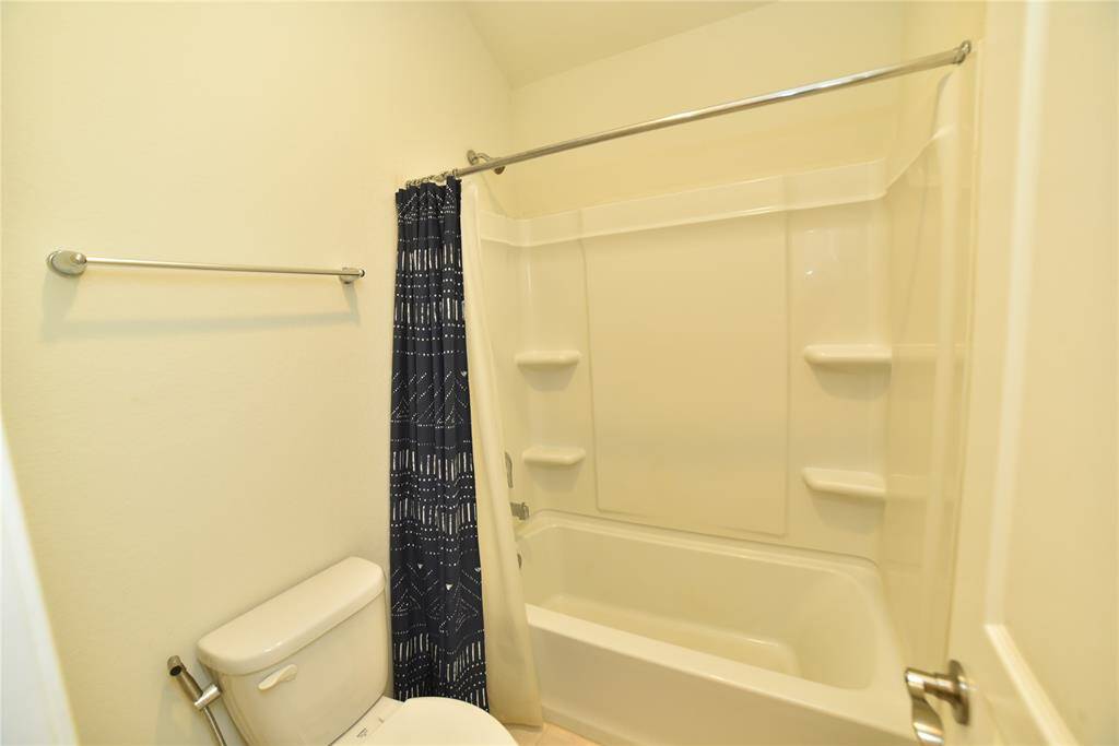 2nd Bathroom (11'4x4'7"). This is a compact bathroom featuring a bathtub with built-in shelving, a shower curtain, and a toilet.