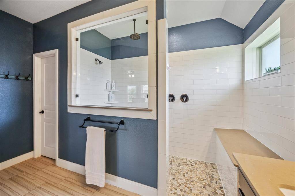 The beautiful walk-in shower adds a touch of luxury to this well-designed primary suite.