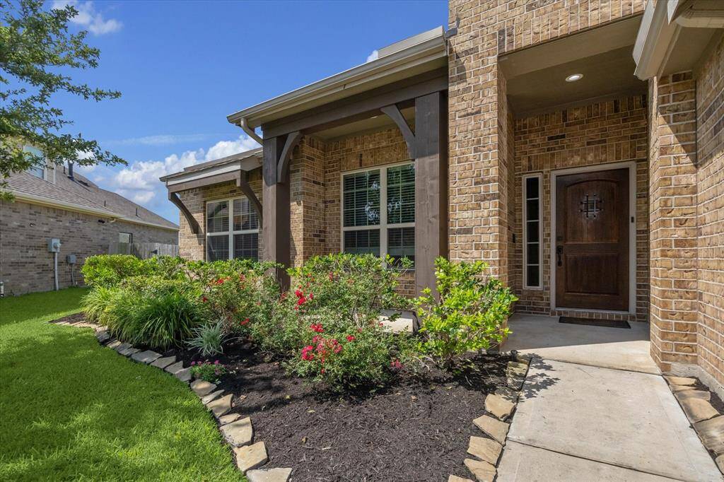 Front entry with well maintained landscaping. The porch is covered, offering a cozy spot to enjoy the outdoors.