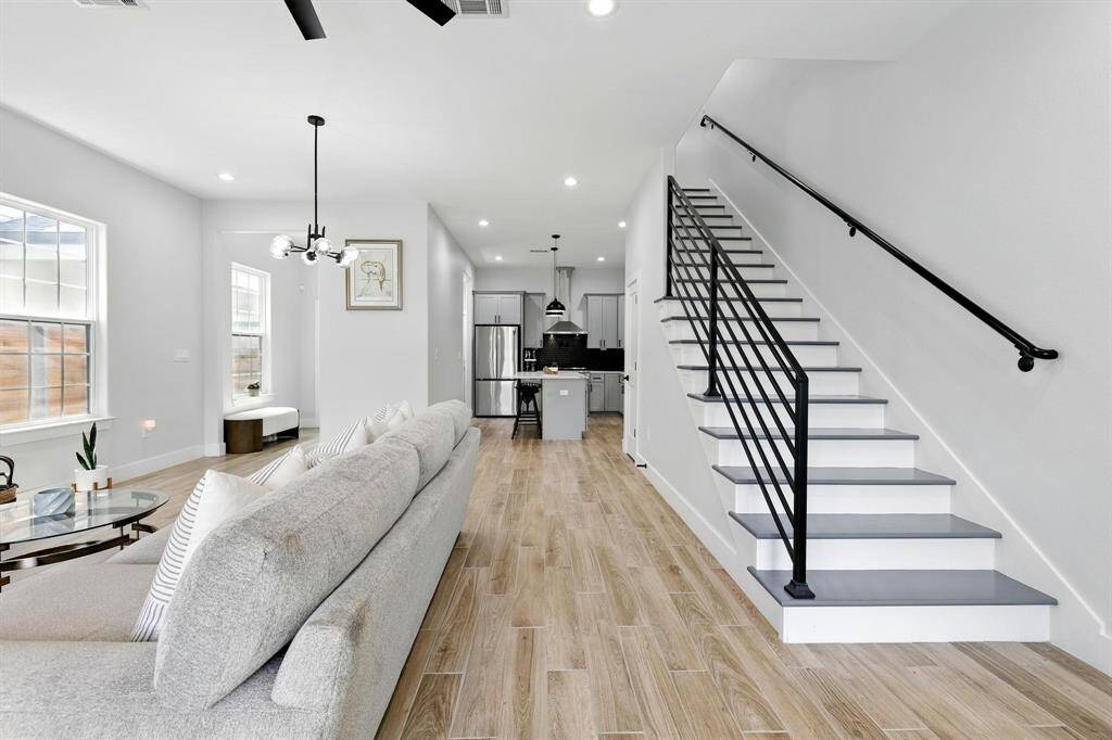 A sleek, open staircase with modern railing and clean lines leads you to the second floor of this stunning home.