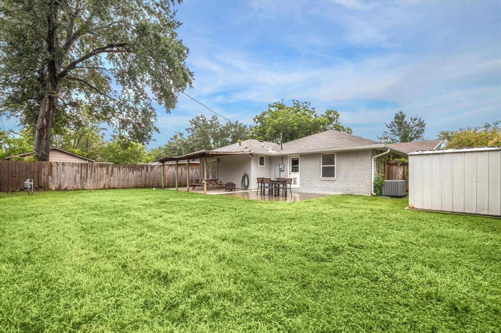 Spacious backyard with covered/uncovered patio space and large storage shed.