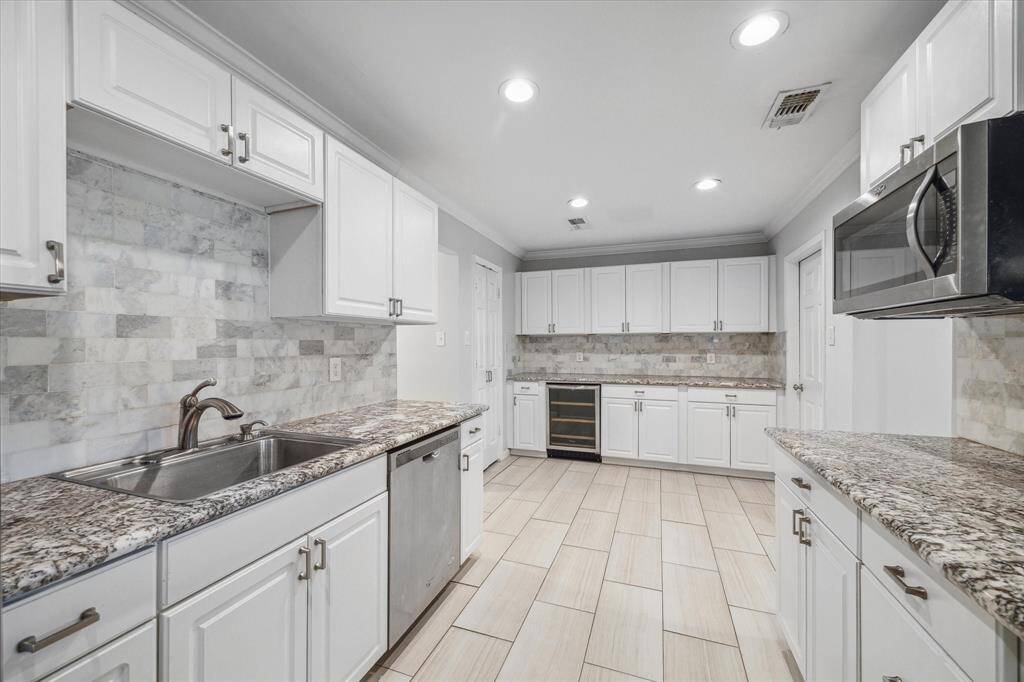 Another view of the kitchen with stainless steel appliances, ample counter space, and large pantry.