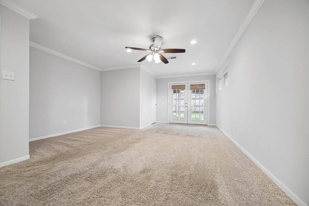 Enormous primary bedroom with French doors leading to the covered patio.