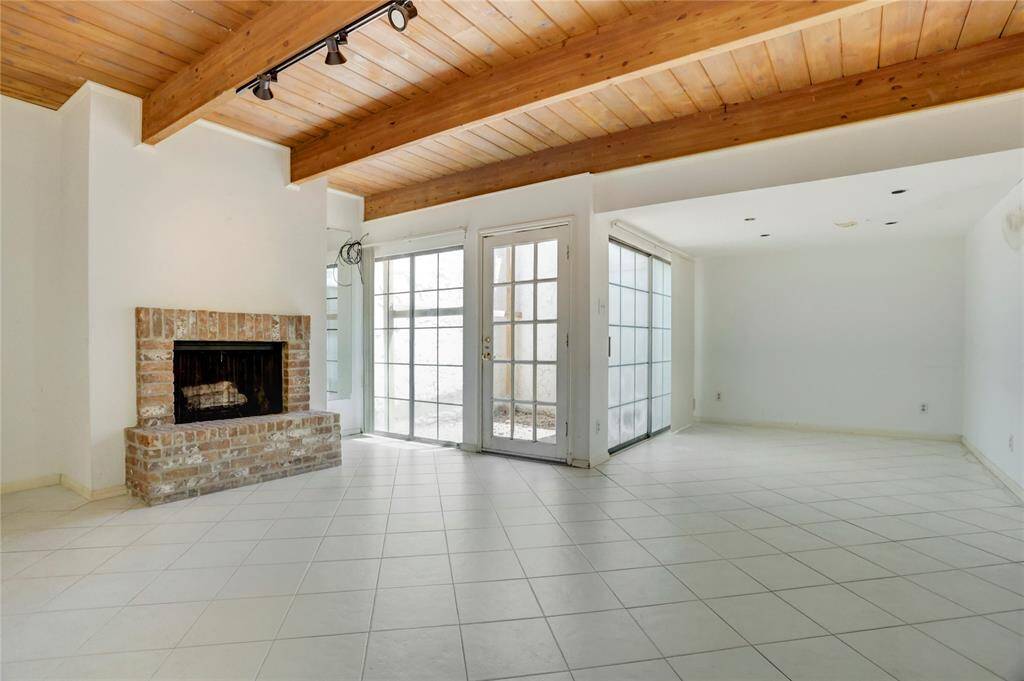 The 18x22 SF living room has exposed beams, track lighting, and wood burning fireplace.