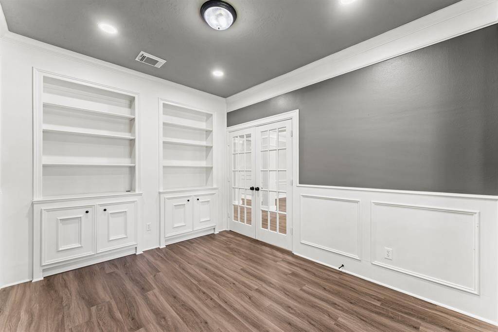 Updated study with french doors, wainscoting, recessed lighting, and built-ins!