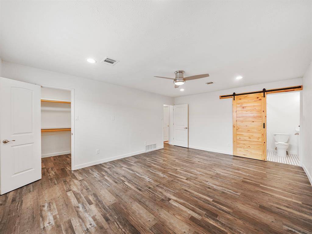 Large primary bedroom with laminate floor. Plenty of space for a King size bed.